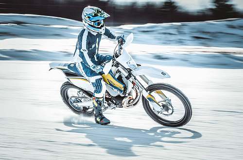 vehicle person riding on black and white motocross dirt bike motorbike