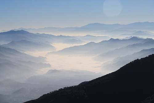 nature aerial photography of mountain range covered in clouds at daytime grey