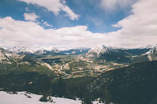 nature aerial photography of mountains under white cloudy skies outdoors
