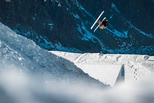 snow biplane flying near mountain outdoors