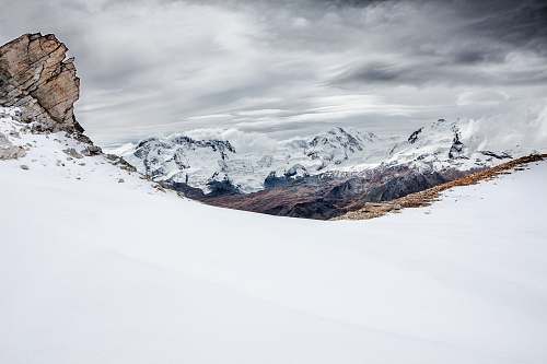 snow brown mountain covered with snow under dark cloudy sky nature