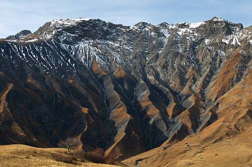 nature gray mountain cover by snow during daytime mountain range