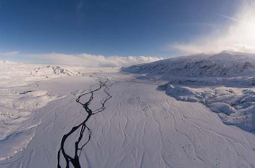 iceland landscape photo of snowy mountains under cloudy sky during daytime ice