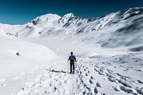 nature man walking on snow field near mountain snow