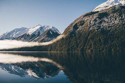 nature mountain reflecting on body of water snow