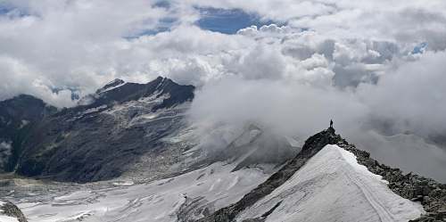 outdoors person standing on top of mountain covered with snow rubble