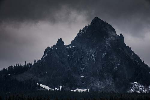 peak rocky mountain under dim sky alps