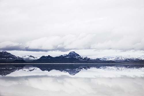nature snow capped mountain under white clouds in mirror reflection photography mountains