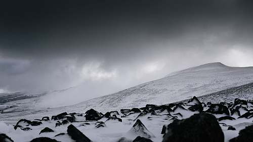 grey snow covered mountain under gray clouds at daytime snow