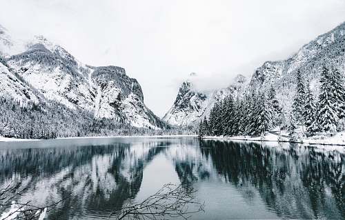ice snow-covered mountains and trees near lake outdoors