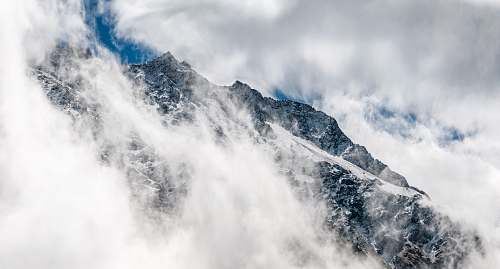 nature snowy mountain covered with fogs clouds
