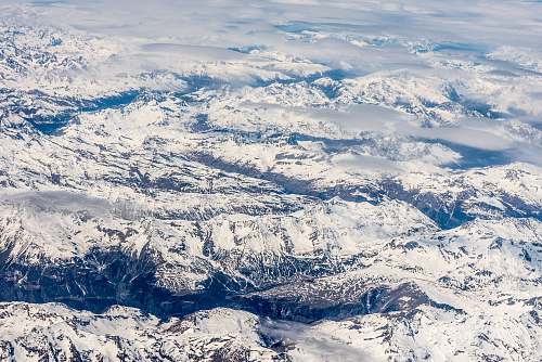 nature snowy mountains beside boy of water under blue sky during daytime snow