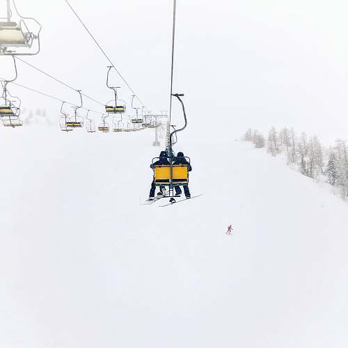 krvavec two person riding on cable transportation through top of the hill during winter cerklje na gorenjskem
