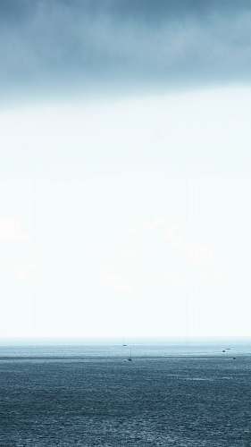 ocean body of water under gray cloudy sky sea