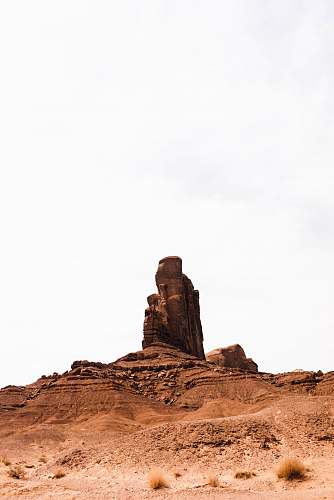 outdoors brown rock formation under white sky monument valley