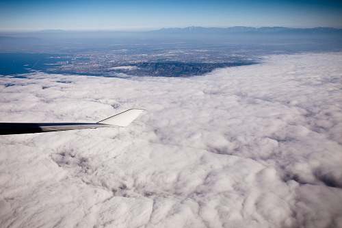 outdoors grey aircraft wingtip on flight above white clouds scenery