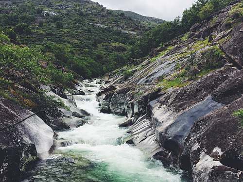 waterfall river between mountain peaks water