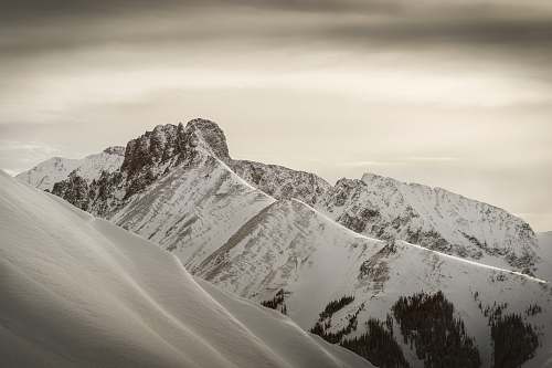 mountain snow-covered mountains under gray clouds during daytime alps