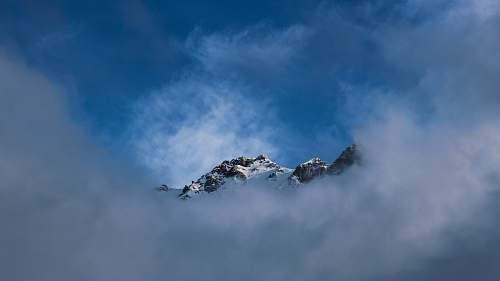 mountain snow top mountain covered with fog during daytime alps