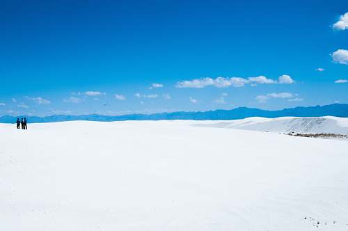 blue three person standing on snowfield snow