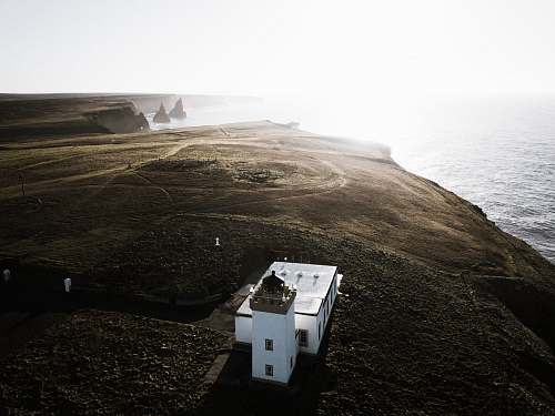 sea aerial photo of white house near body of water water