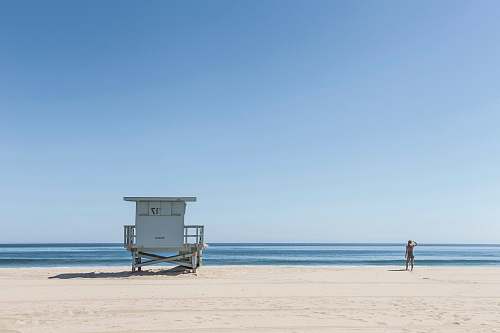beach person standing near lifeguard house ocean