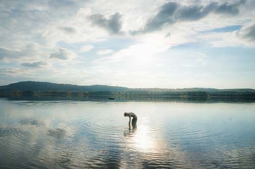 water person standing on body of water lake