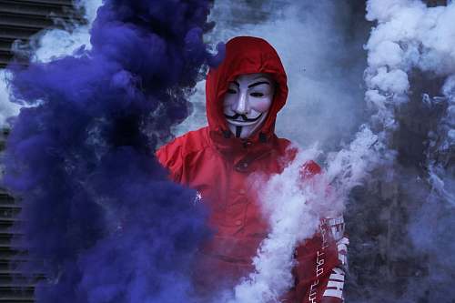 human man wearing red jacket surrounded by purple and white smoke person