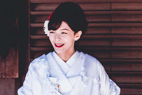 person woman wearing white top near black window blinds in room japan