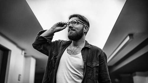 human grayscale photo of man standing black-and-white