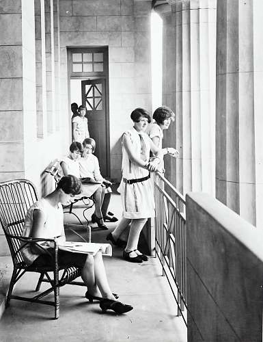 human group of woman sitting and standing beside railing black-and-white