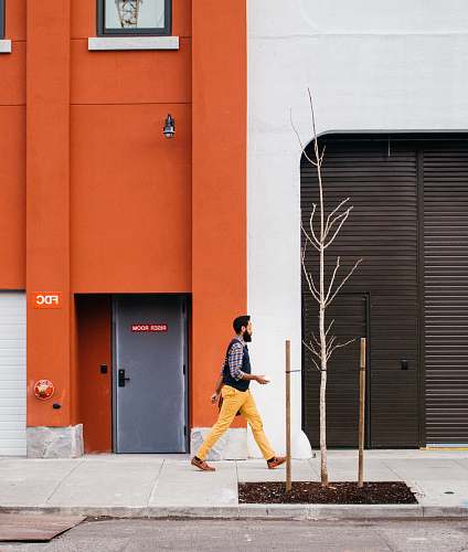 human man walking beside building people