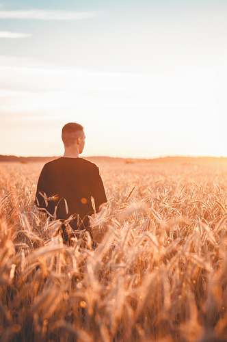 nature man wearing black shirt standing on grasses outdoors