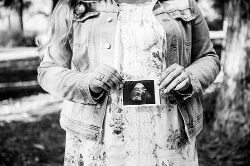 human woman holding ultra sound result film black-and-white