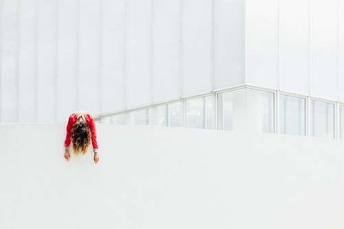 human woman in red jacket on white painted concrete railings building