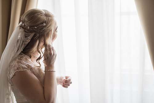 people woman wearing white bridal gown near window curtain human