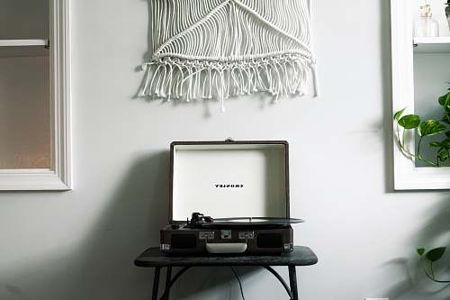 white black Crosley turntable on black table near white wall record player