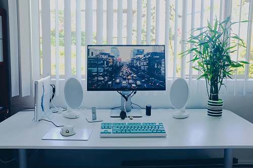 table black flat screen computer monitor; keyboard; speakers; mouse on desk desk