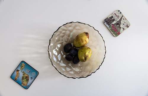 food round clear glass bowl fruits on the white table