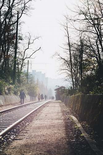 railway group of people walking on railroad train track