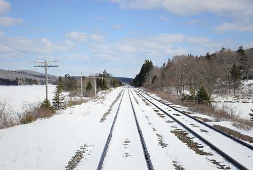 rail railway covered with snow under cloudy sky train track