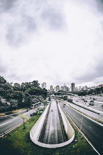 freeway aerial view of underground road and city buildings at distance tree