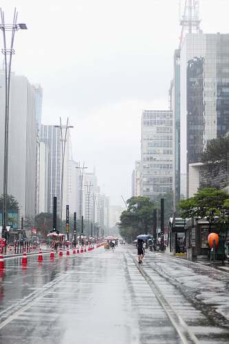 town woman walking on street while raning holding gray umbrella urban