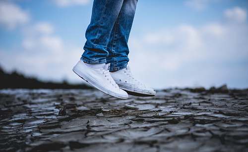 blue person wearing white low-top sneakers jump
