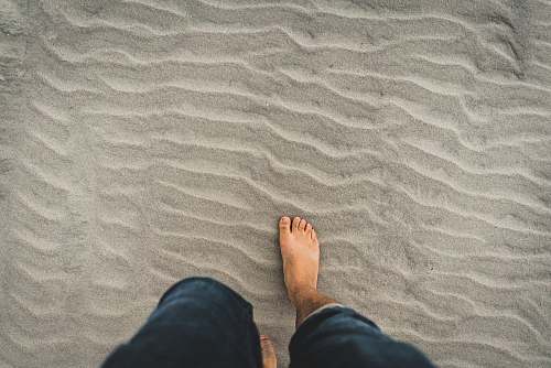 outdoors man in blue denim jeans walking through the sand kiawah island