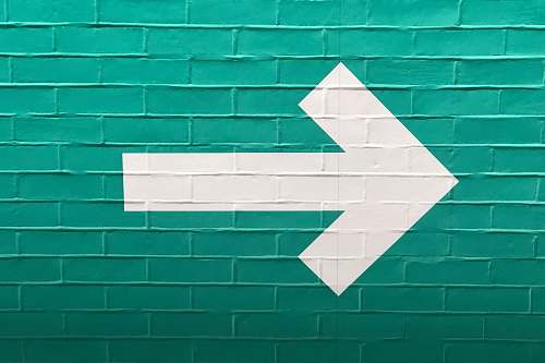 left selective focus photography of white arrow signage direction