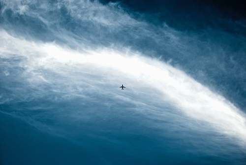 blue silhouette of jet plane on blue sky plane