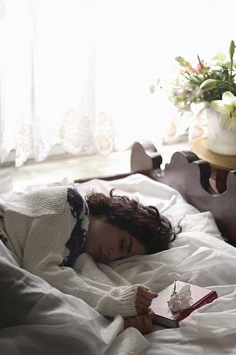 bed woman sleeping on bed beside book vase