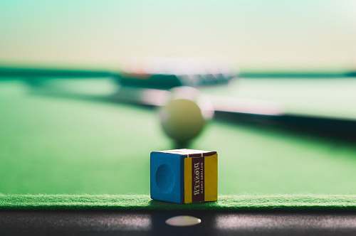 chalk yellow and blue cue stick chalk on green and black pool table blue