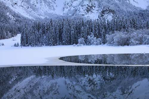 ice body of water near snow coated land mountain